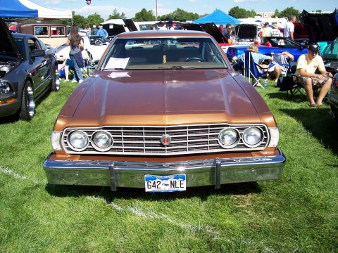 1972 Ford Ranchero - A brown Ford Thunderbird is displayed at an outdoor car show with other vehicles and attendees.