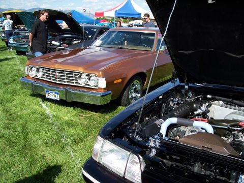 1972 Ford Ranchero - A 1972 Ford Ranchero is displayed at a car show, with another vehicle's engine visible in the foreground.