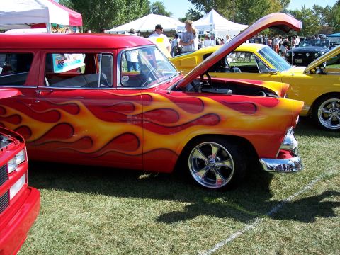 1972 Ford Ranchero - A red station wagon with custom flame decals is displayed at an outdoor car show.