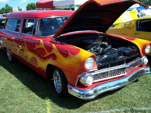 1972 Ford Ranchero - A customized 1955 Ford Fairlane Crown Victoria wagon with flame decals is displayed with its hood open.