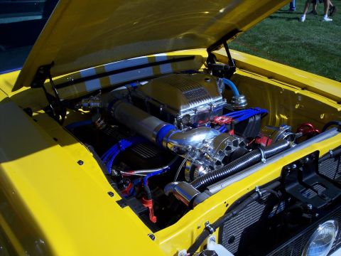 1972 Ford Ranchero - Customized engine bay of a yellow vehicle, a prominent supercharger and polished components.