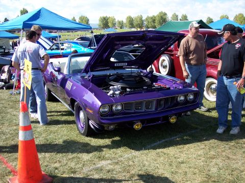 1972 Ford Ranchero - A purple Plymouth Barracuda convertible is displayed with its hood open at an outdoor car show, with several people gathered around.