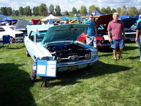 1972 Ford Ranchero - A light blue 1967 Ford Mustang is displayed at an outdoor car show with its hood open.