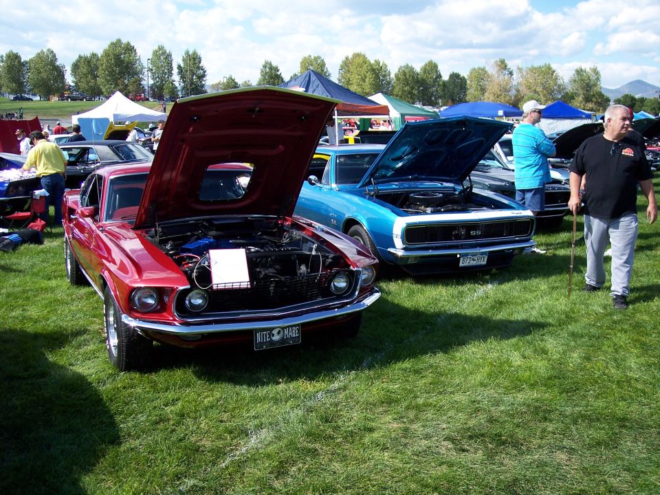 Red 1969 Ford Mustang Mach 1 with hood open, showing engine and a license plate that reads 'NITE 3 MARE'