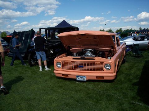 1972 Ford Ranchero - Orange 1970s Chevrolet pickup truck with hood open at an outdoor car show.