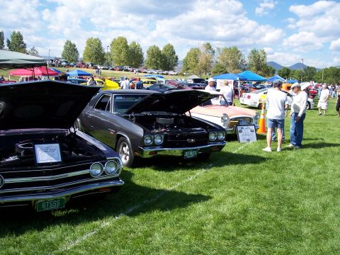 1972 Ford Ranchero - Several classic cars are displayed on a grassy field under a partly cloudy sky at an outdoor event.