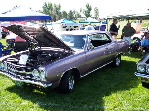 1972 Ford Ranchero - A classic 1966 Chevrolet Chevelle is displayed with its hood up at an outdoor car show event.