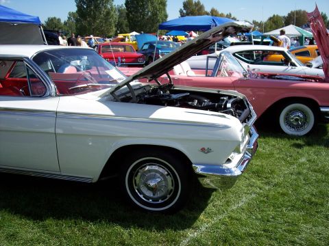1972 Ford Ranchero - A white 1961 Chevrolet Impala convertible is displayed with its hood open at an outdoor car show.