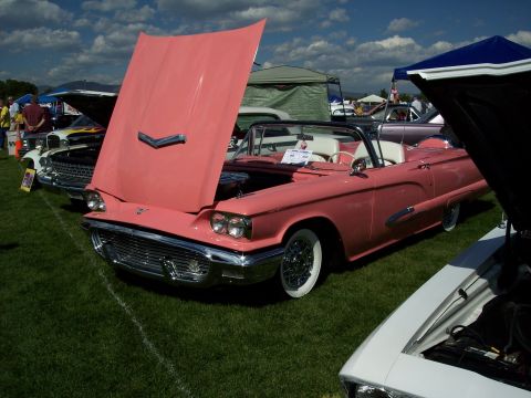 1972 Ford Ranchero - A pink 1958 Ford Thunderbird convertible is displayed with its hood open at an outdoor car show.