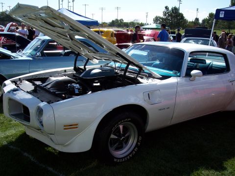 1972 Ford Ranchero - White 1970 Pontiac Firebird Trans Am is displayed with its hood open at an outdoor car show.