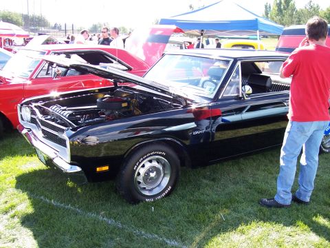 1972 Ford Ranchero - A black Dodge Dart is displayed with its hood open at an outdoor car show.