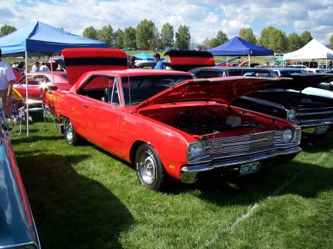 1972 Ford Ranchero - A red 1969 Dodge Dart coupe is displayed with its hood open at an outdoor car show.