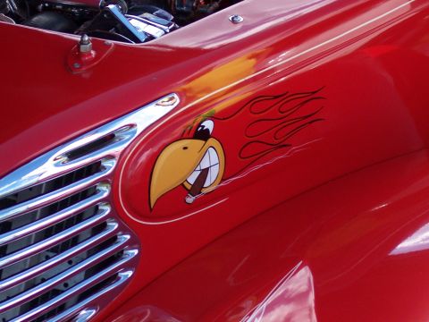 1972 Ford Ranchero - A cartoon bird with a cigar and flames is painted on the red fender of a vehicle.