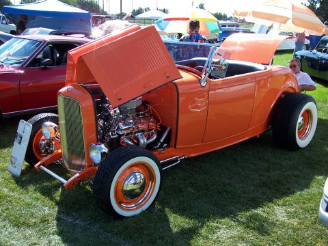1972 Ford Ranchero - An orange hot rod convertible is displayed with its hood open, revealing a detailed engine.