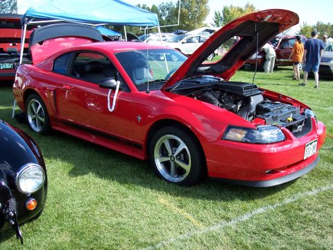 1972 Ford Ranchero - Red Ford Mustang with its hood open at an outdoor car show.