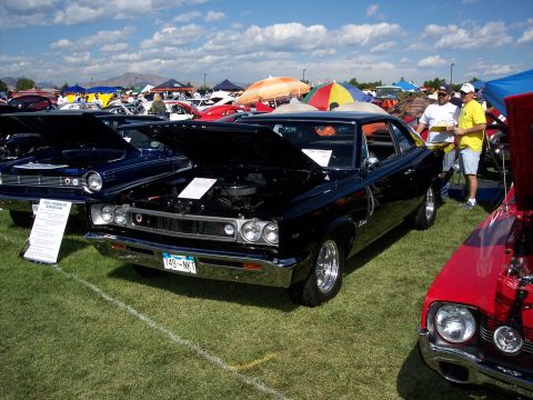 1972 Ford Ranchero - A black 1968 AMC Rambler American coupe is displayed at an outdoor car show with other vehicles and tents in the background.