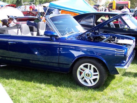 1972 Ford Ranchero - A blue convertible is displayed at an outdoor car show with its hood open, revealing the engine compartment.