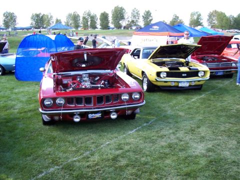 1972 Ford Ranchero - A red muscle car with its hood open is displayed on a grassy field.