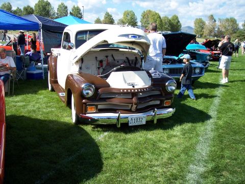 1972 Ford Ranchero - A classic 1950 Chevrolet pickup truck is displayed with its hood open at an outdoor car show.