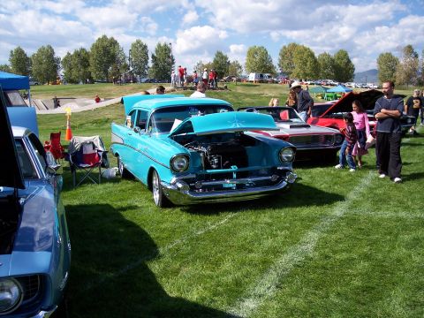 1972 Ford Ranchero - A turquoise 1957 Chevrolet Bel Air is displayed with its hood open at an outdoor car show, alongside other vehicles.