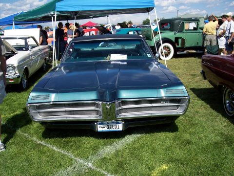 1972 Ford Ranchero - A 1969 Pontiac Grand Prix is displayed at an outdoor car show with other vehicles visible.