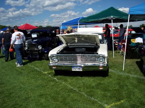 1972 Ford Ranchero - White 1964 Ford Falcon on display at an outdoor car show event.