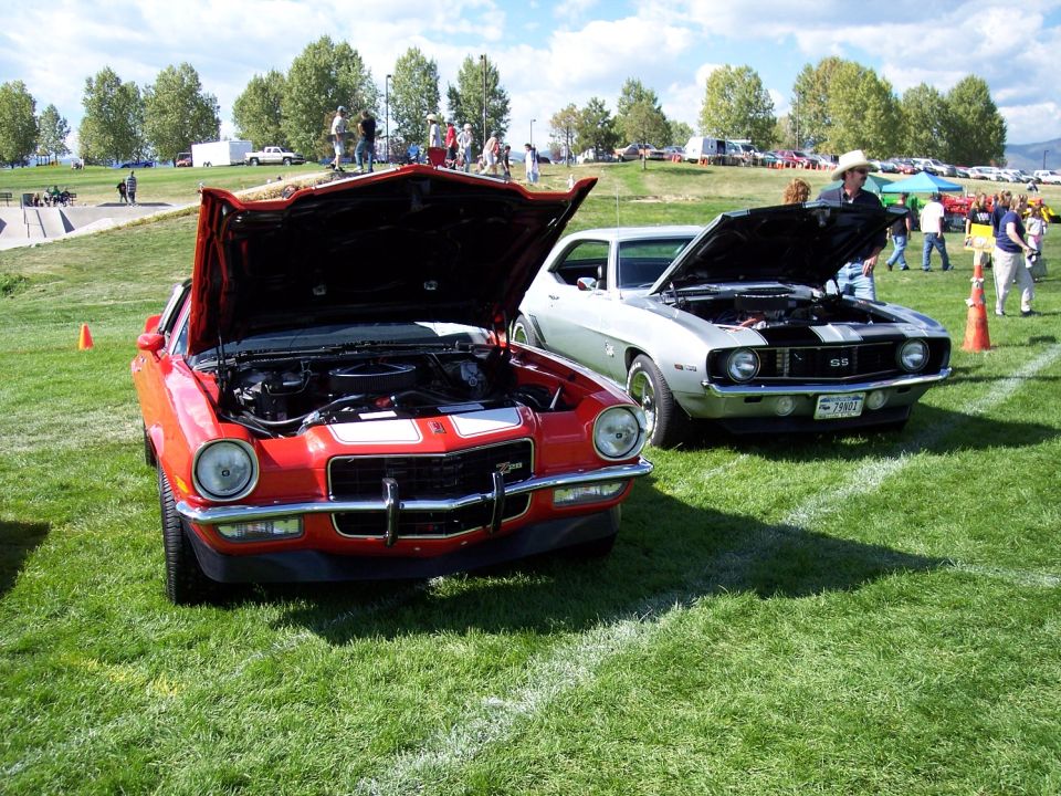 Red 1970 Chevrolet Camaro SS with hood open, parked on grass