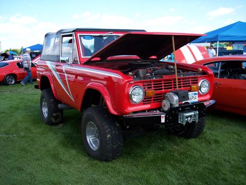 1972 Ford Ranchero - This red Ford Bronco has its hood open, revealing the engine bay and a winch mounted on the front bumper.