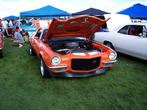 1972 Ford Ranchero - This orange muscle car, likely a 1970 model, is displayed with its hood open, revealing the engine and Z/28 badging.