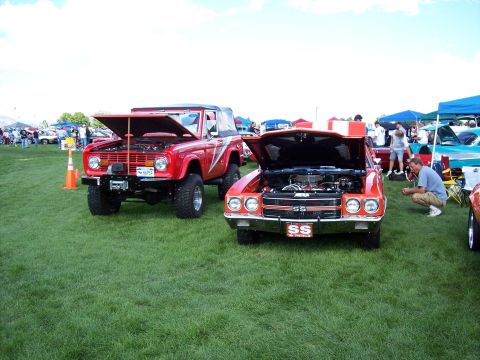 1972 Ford Ranchero - Two classic American cars, a Ford Bronco and a Chevrolet Chevelle SS, displayed with their hoods up at an outdoor event.
