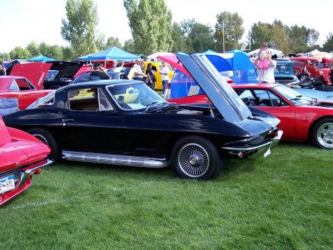 1972 Ford Ranchero - A black 1963 Chevrolet Corvette Sting Ray coupe is displayed with its hood open at an outdoor car show.