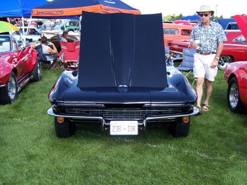 1972 Ford Ranchero - A black 1965 Chevrolet Corvette is displayed with its hood open at an outdoor car show.