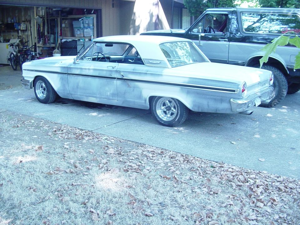 Primer-gray 1964 Ford Fairlane hardtop parked in a driveway