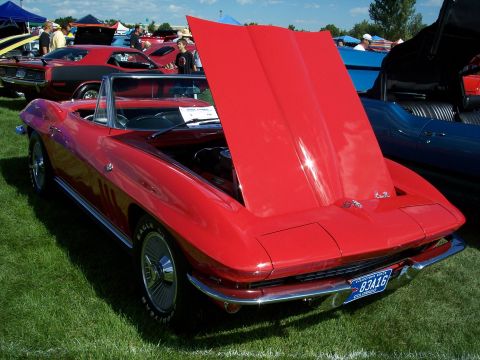 1972 Ford Ranchero - A red 1965 Chevrolet Corvette convertible is displayed with its hood open at an outdoor car show.