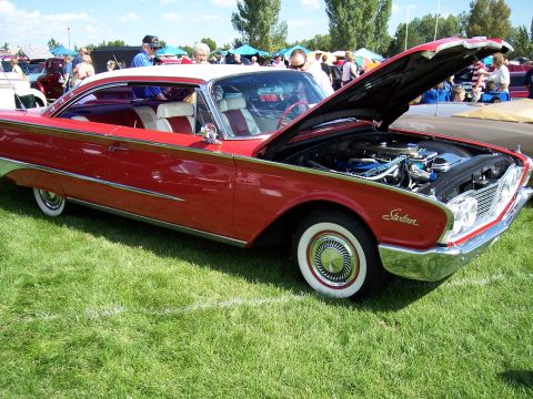 1972 Ford Ranchero - A classic red and white 1960 Ford Starliner is displayed with its hood open at an outdoor car show.
