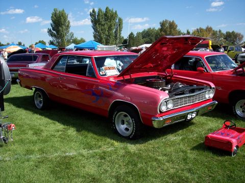1972 Ford Ranchero - A red coupe with flame decals is displayed with its hood open at an outdoor car show.