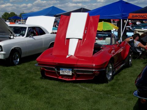 1972 Ford Ranchero - A red 1965 Chevrolet Corvette convertible is displayed with its hood open, revealing white racing stripes and engine details.