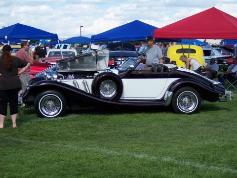 1972 Ford Ranchero - Custom convertible with exposed engine and side-mounted spare tire on display at an outdoor event.