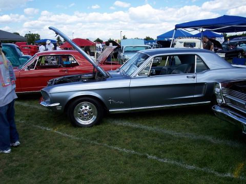 1972 Ford Ranchero - A gray 1967 Ford Mustang coupe is displayed with its hood open at an outdoor car show.