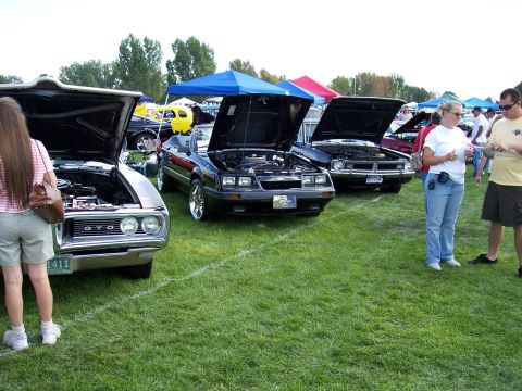 1972 Ford Ranchero - A 1972 Ford Ranchero is displayed with its hood open at an outdoor car show, alongside other vehicles.