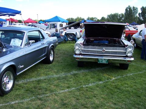 1972 Ford Ranchero - Two cars with hoods open at an outdoor car show, one is a 1967 Ford Mustang.