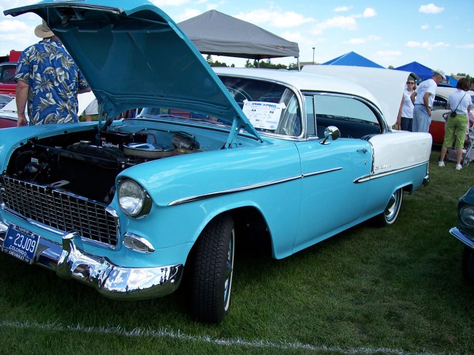 Blue and white 1955 Chevrolet Bel Air with hood open, showing engine. Colorado license plate