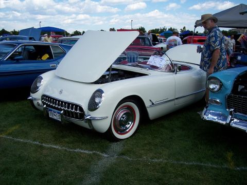 1972 Ford Ranchero - White 1955 Chevrolet Corvette on display at an outdoor car show.