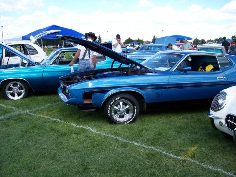 1972 Ford Ranchero - A blue 1971 Ford Mustang Mach 1 is displayed at an outdoor car show with its hood open.