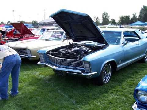 1972 Ford Ranchero - A light blue 1967 Buick Riviera is displayed with its hood open at an outdoor car show.