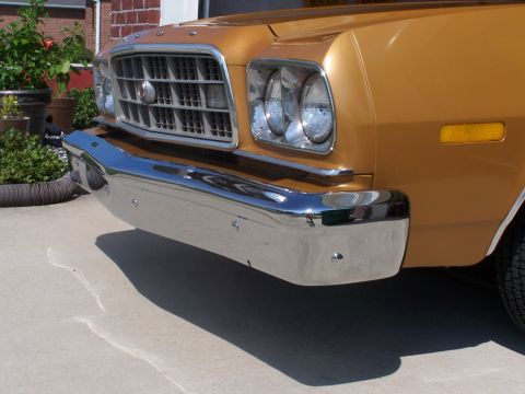 1973 Ford Ranchero - The chrome bumper and grille of a gold 1972 Ford Ranchero are visible from the front.