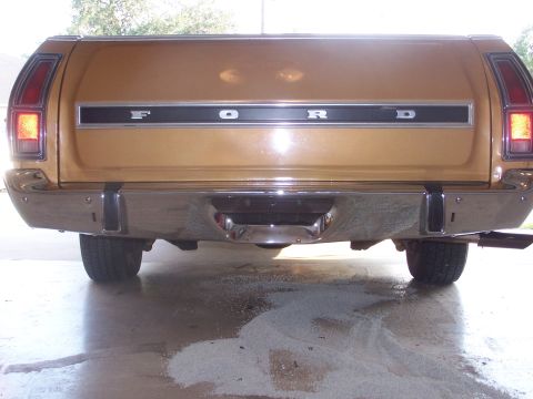 1973 Ford Ranchero - Rear view of a gold 1973 Ford Ranchero, showing the tailgate with prominent FORD lettering and chrome bumper.