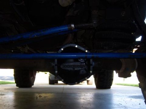 1995 Ford Bronco - The underside of a vehicle reveals a 'ROCKCRUSHER' differential cover, with another vehicle partially visible behind it.