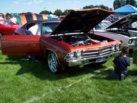1972 Ford Ranchero - A 1969 Chevrolet Chevelle SS is displayed with its hood and door open at an outdoor car show.