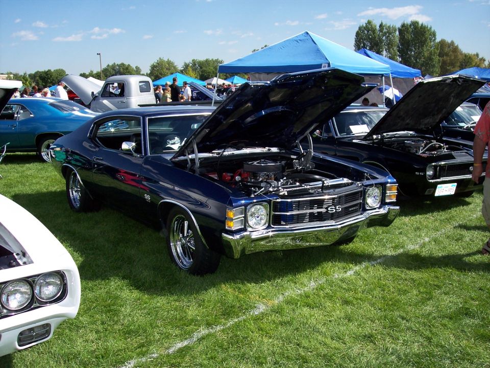 Dark blue 1970 Chevrolet Chevelle SS with hood open, parked on grass at car show